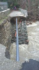 A pipe is left exposed after Forge Bridge, Keswick, is washed away.