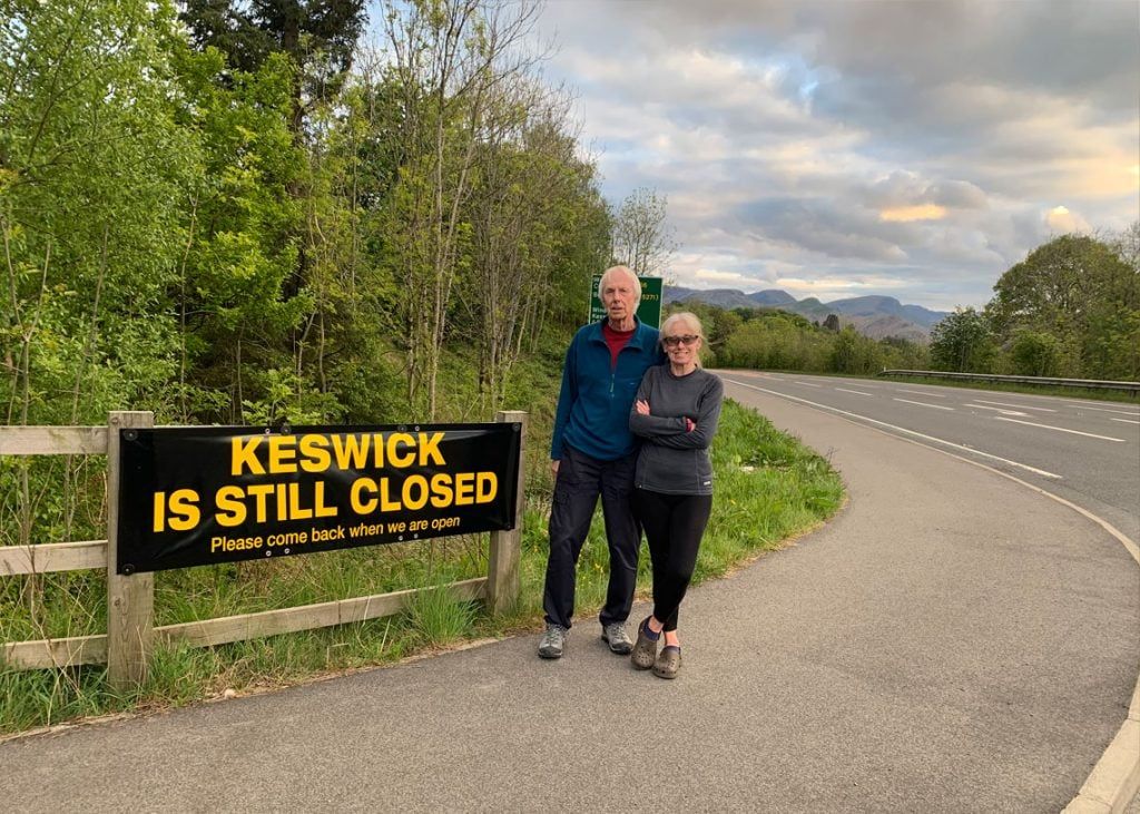 Keswick mayor Cll David Burn and his wife Elaine with one of the signs saying 'Keswick is still closed - Please come back when we are open'