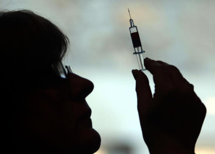 woman in silhouette holding a syringe