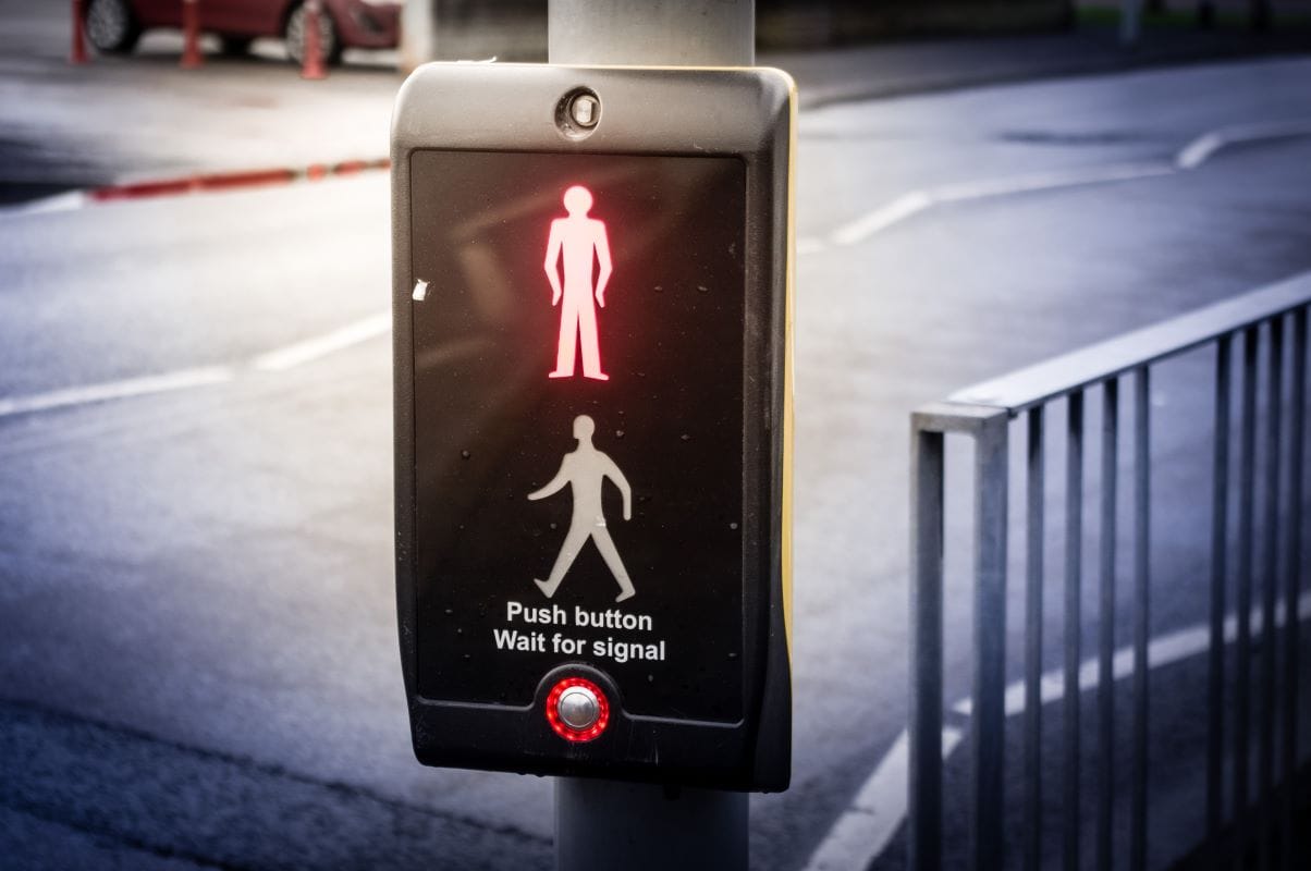 Crossing meaning. A button on a pedestrian Crossing. Traffic Lights stop start go.