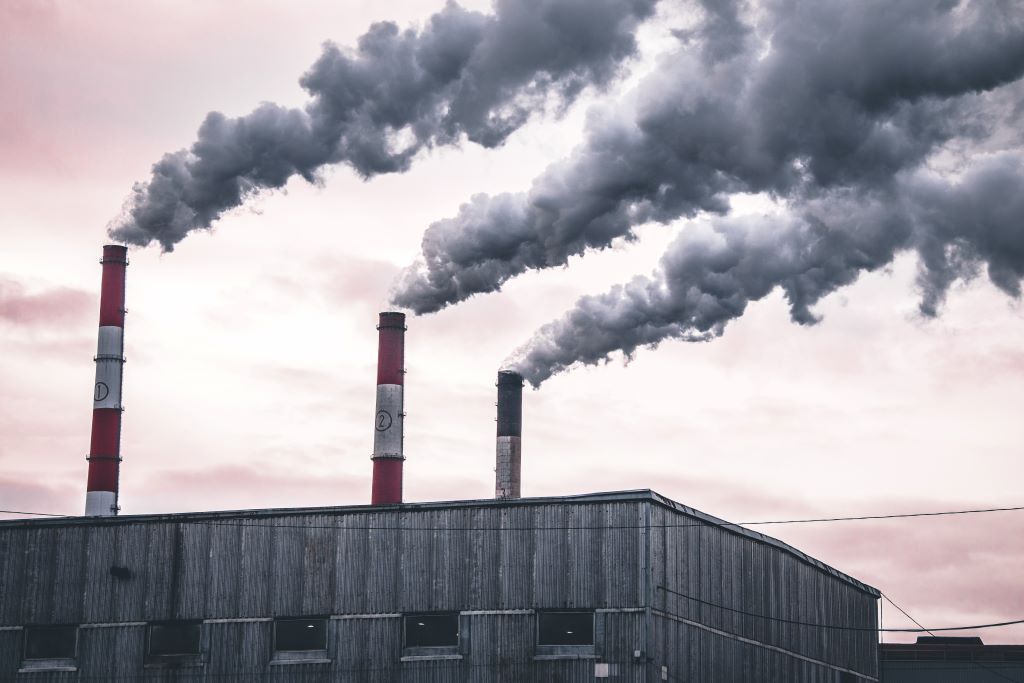 Three chimneys belching smoke into the atmosphere