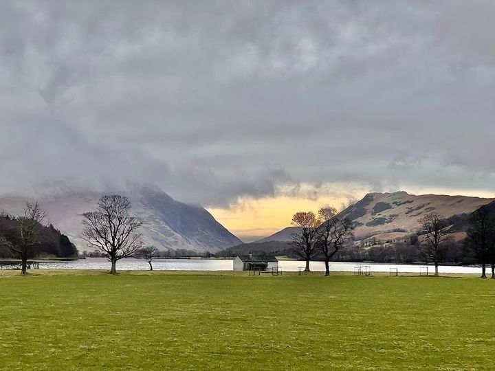 Looking across field towards mountains shrouded in mist