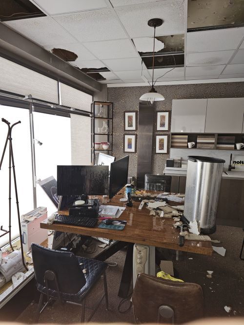 Shop office with water damage to ceiling tiles and computers